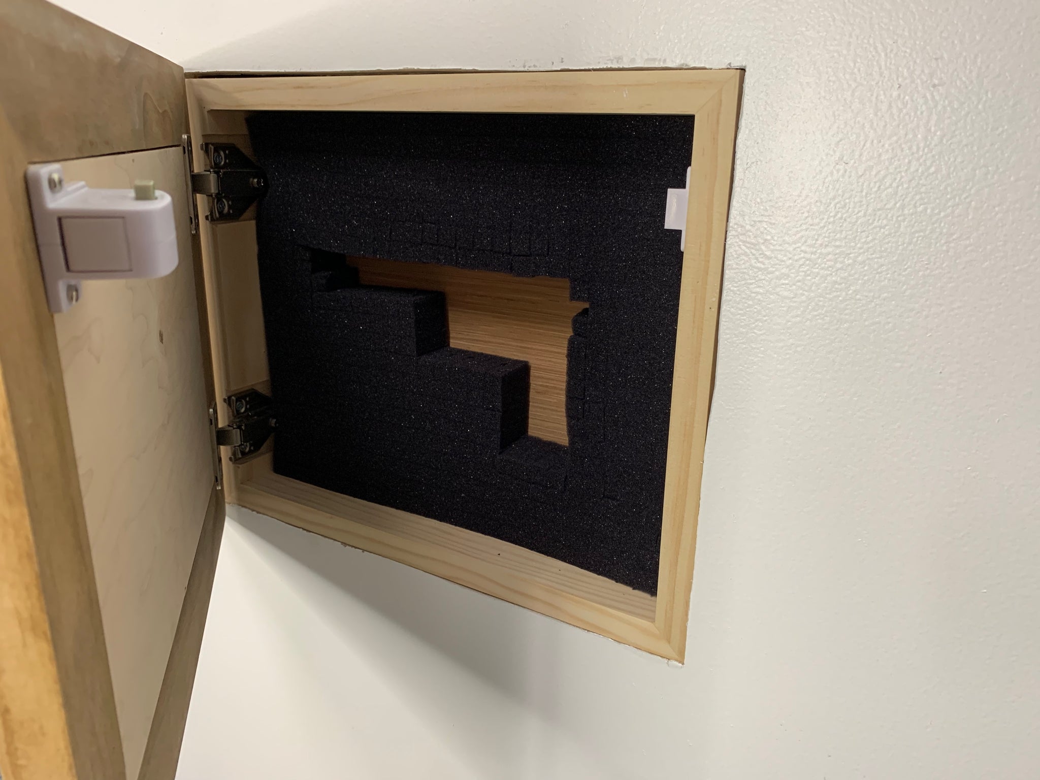 Bellewood Designs recessed hidden gun storage installed in wall, open showing empty foam handgun cutouts and magnetic lock